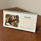 Desktop Flip Calendar with an aye aye illustration on a wooden surface