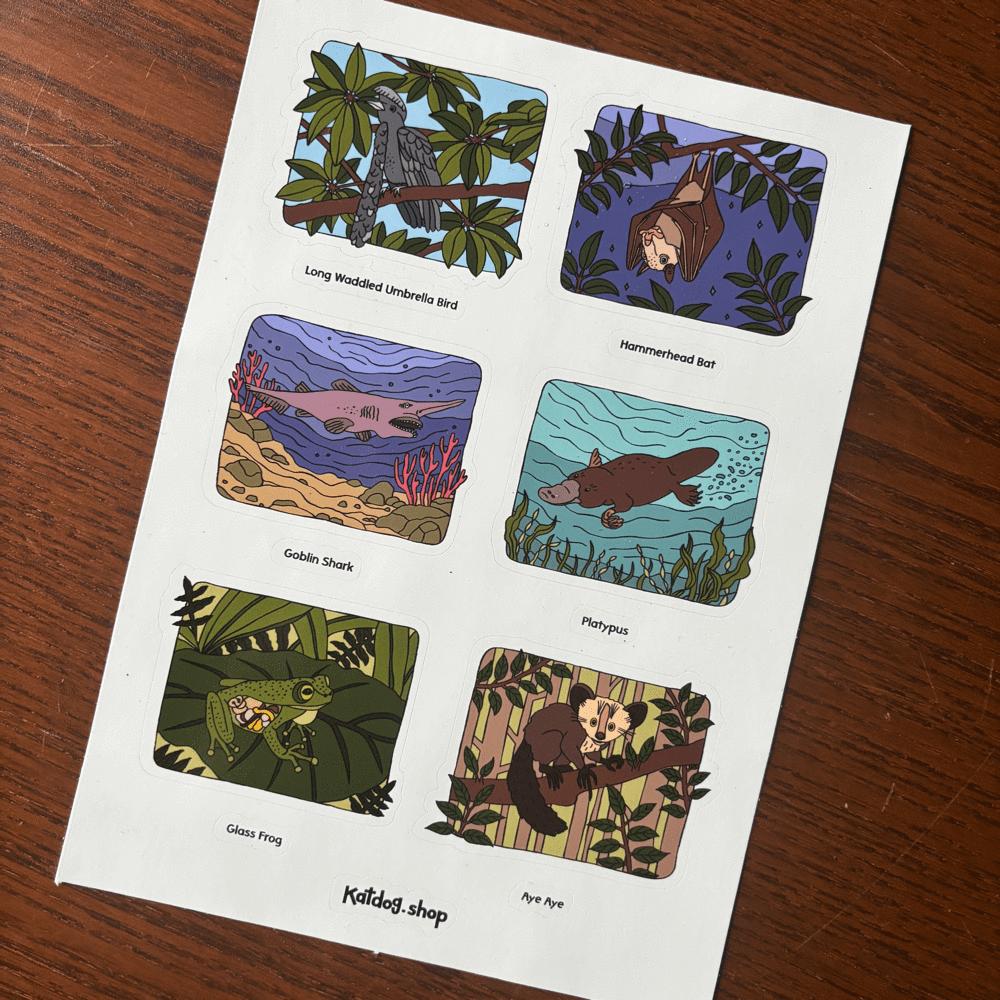 Sheet of cards with illustrations of weird animals on a wooden surface